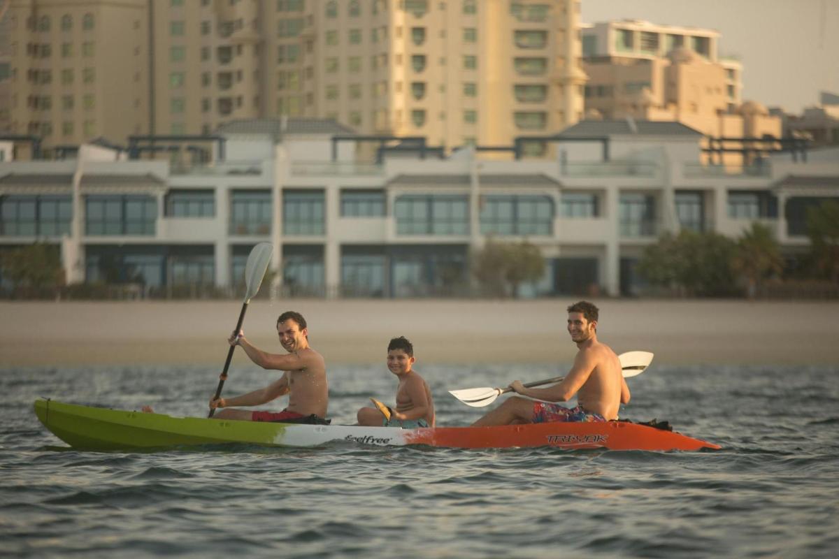 three men are sitting on kayaks in the water