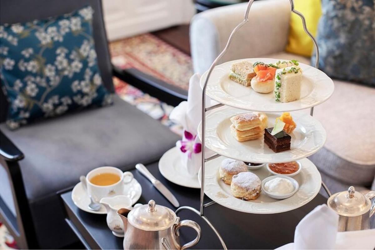 uma mesa com três pratos de doces e uma xícara de café