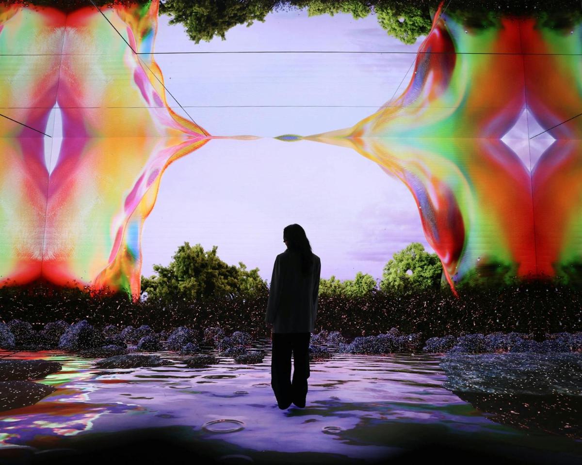 a woman standing in front of a large painting