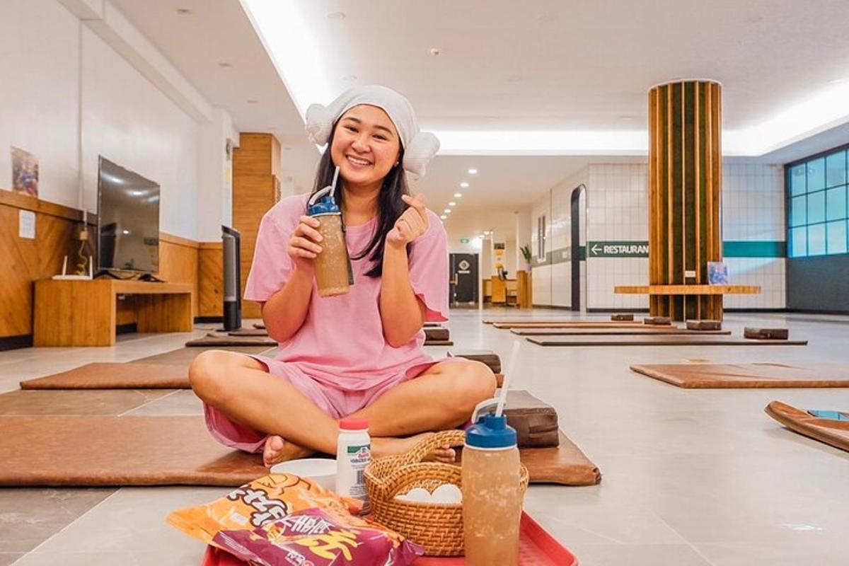 a woman sitting on the floor holding a drink
