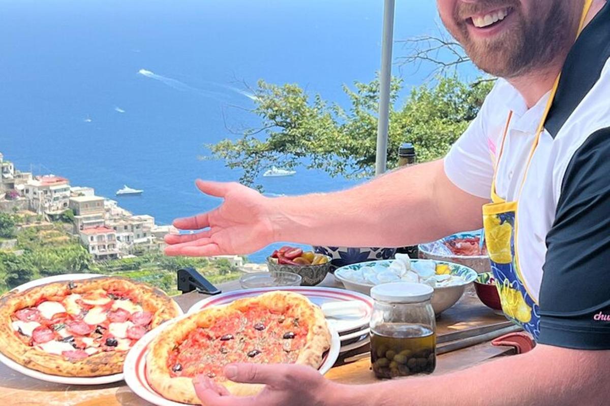 muž sedící u stolu se dvěma pizzami