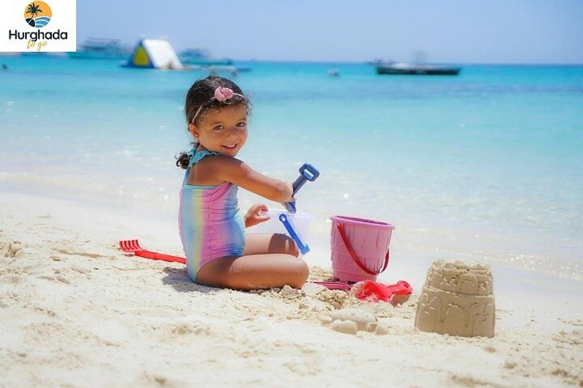 a little girl playing in the sand on the beach