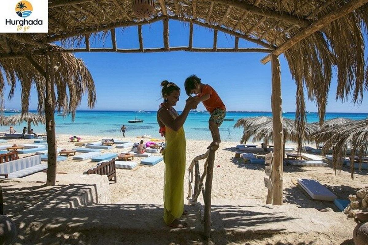 a woman holding a child on a beach
