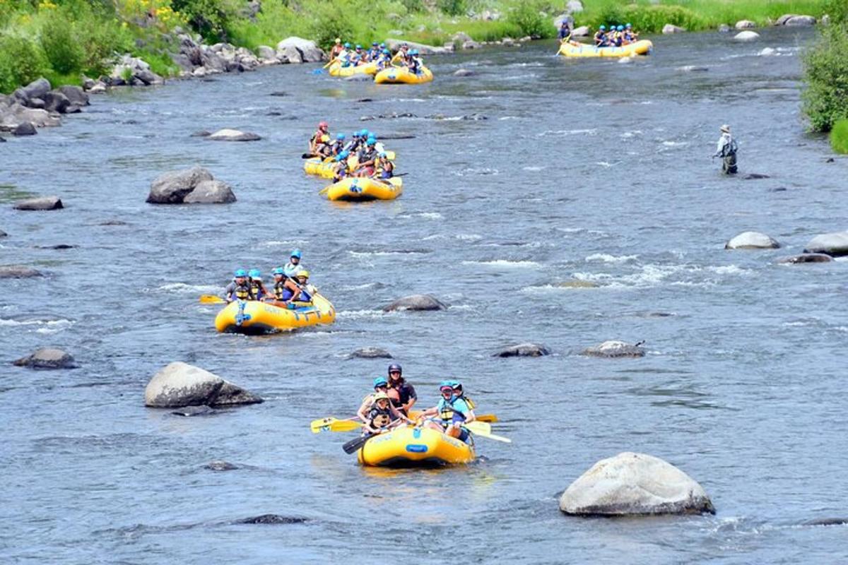 a group of people rafting down a river in yellow rafts