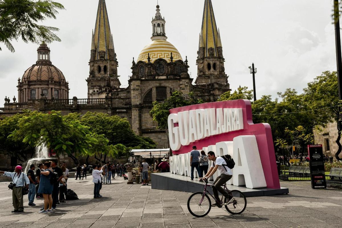 una persona que va en bicicleta delante de un edificio