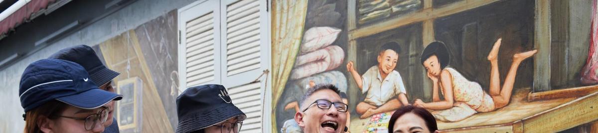 three people standing in front of a painting on a wall