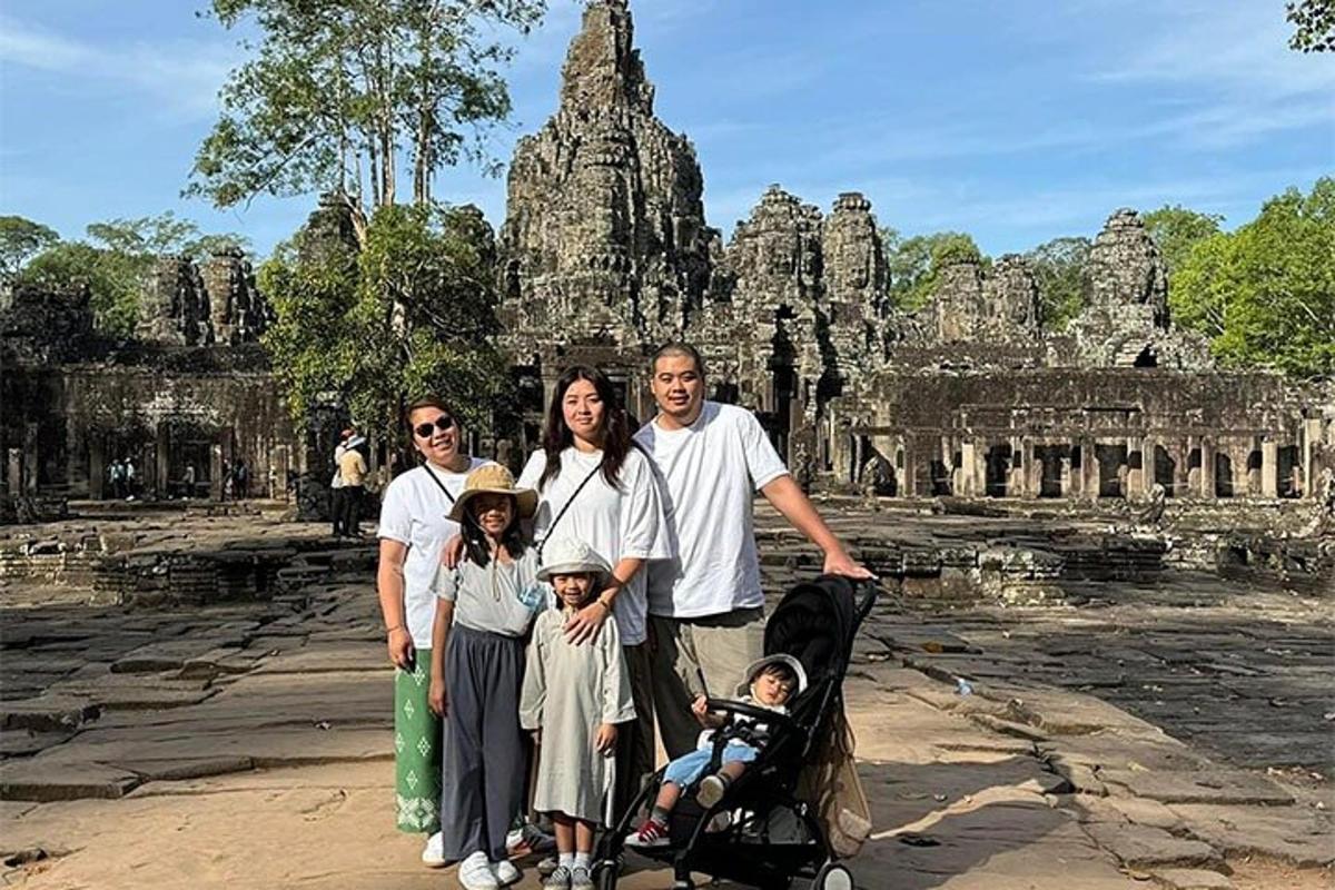 sekeluarga bergambar di hadapan kuil