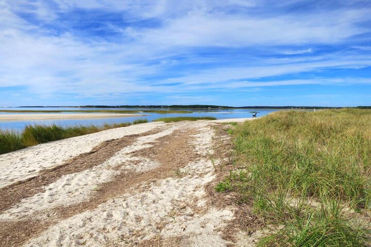 a dirt road next to a body of water