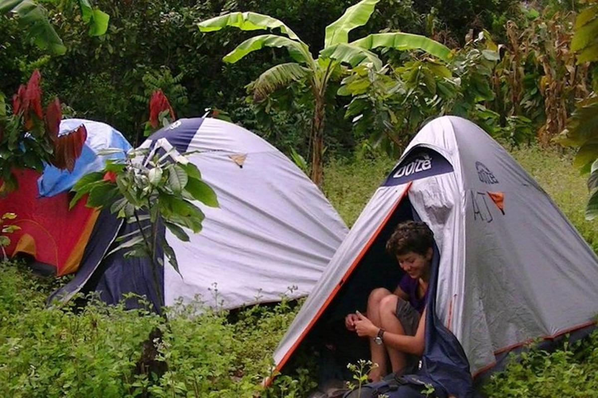 una dona asseguda dins d'una tenda en un camp