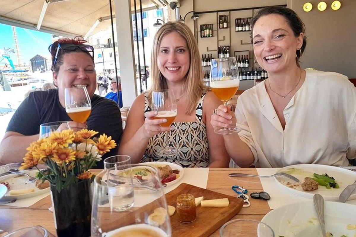 tre donne sedute a un tavolo con bicchieri di vino