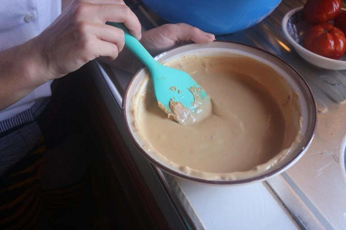osoba držící lžíci v hrnci s jídlem