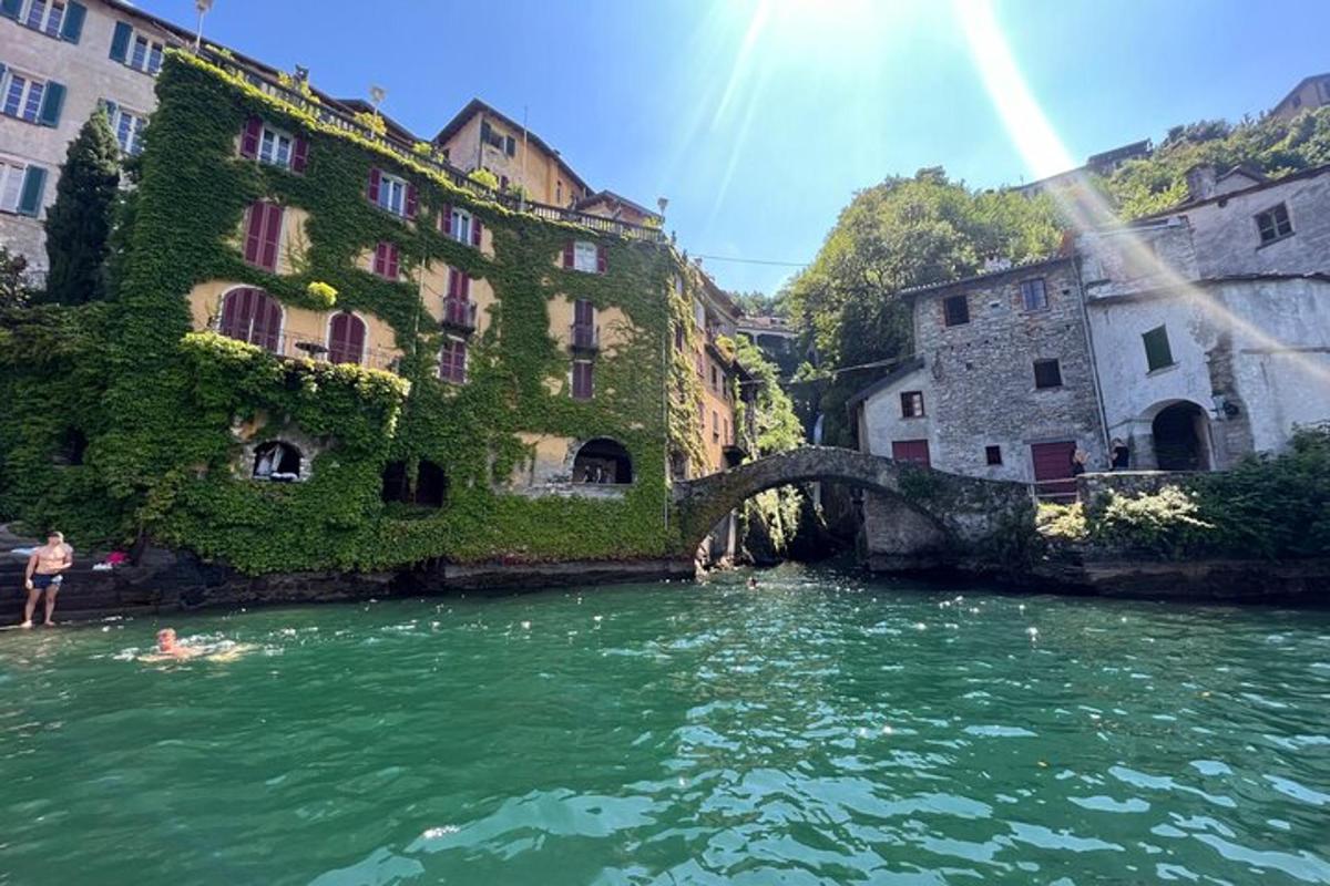 a group of people swimming in a river with buildings