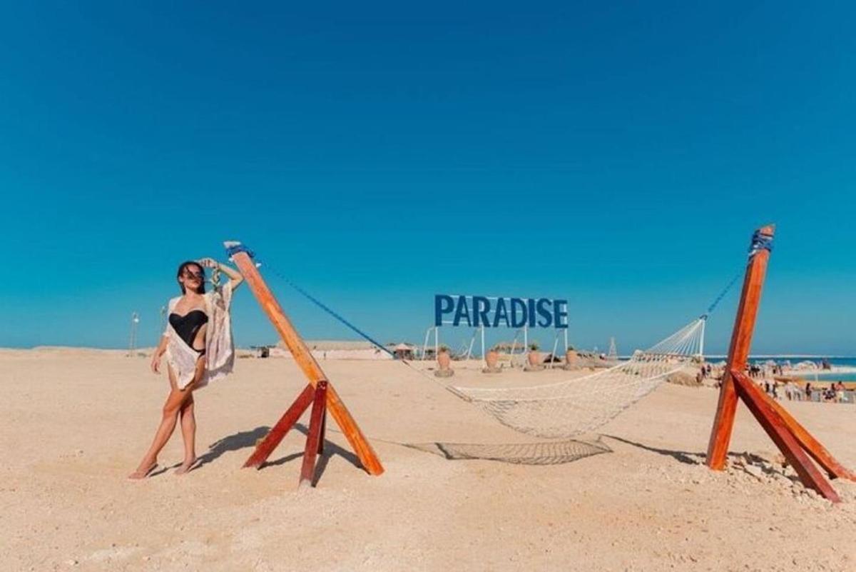 a woman standing next to a hammock on the beach