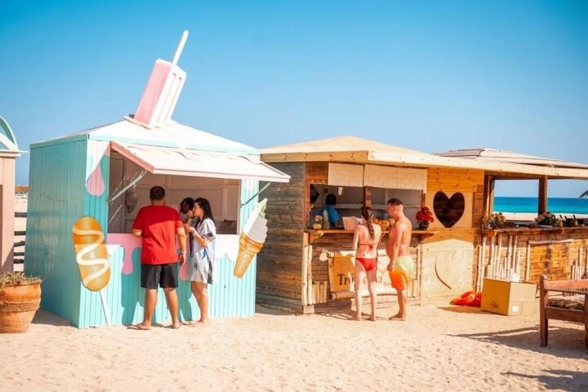 un grup de persones dempeus fora d'una barraca de platja