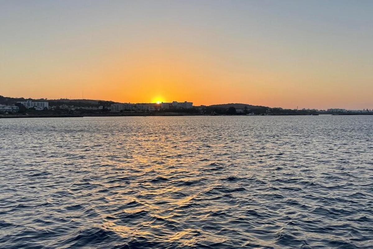 um pôr do sol sobre um grande corpo de água
