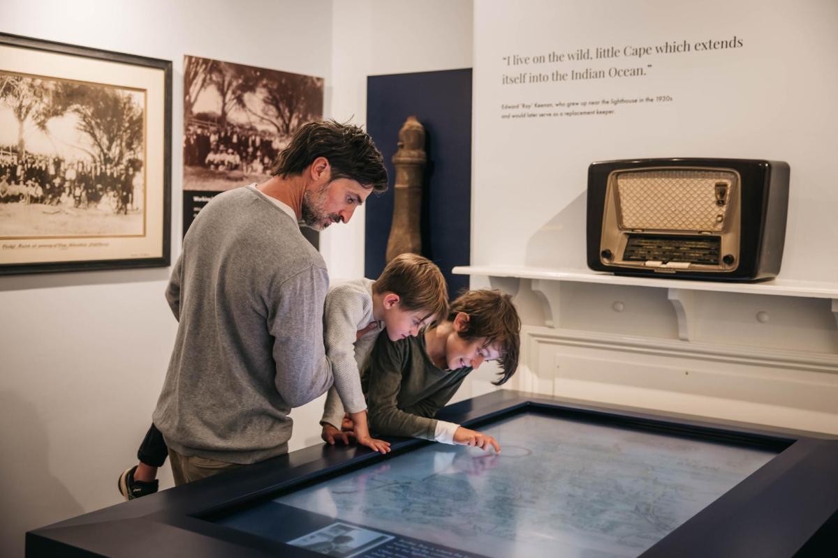 a man and two children looking at a table with a television