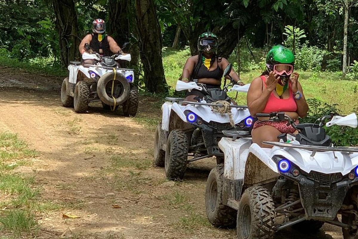 trois personnes conduisant des VTT sur un chemin de terre