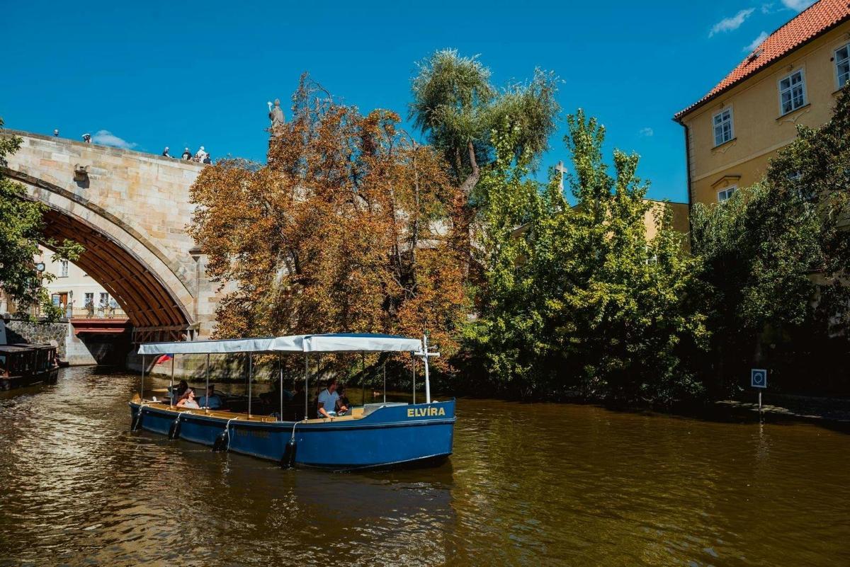 Modrá loď ve vodě poblíž mostu