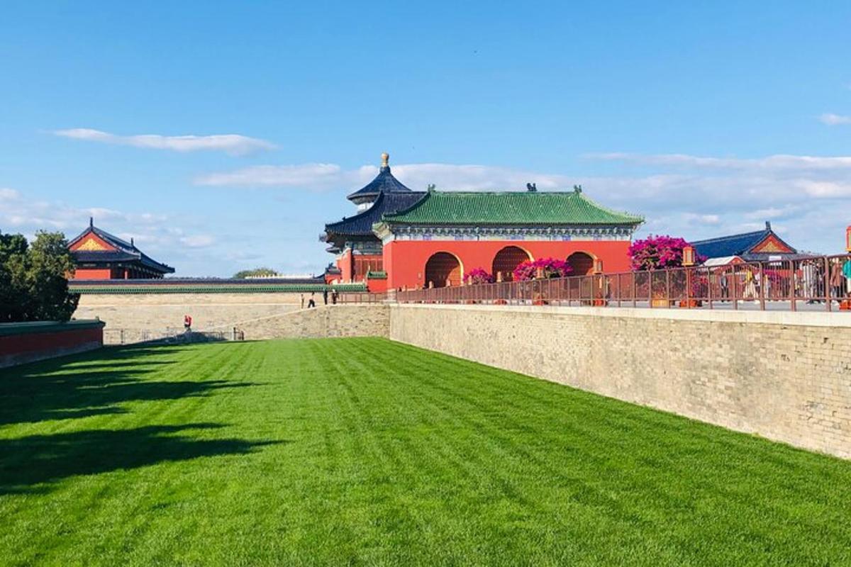 a castle with a wall and a green lawn