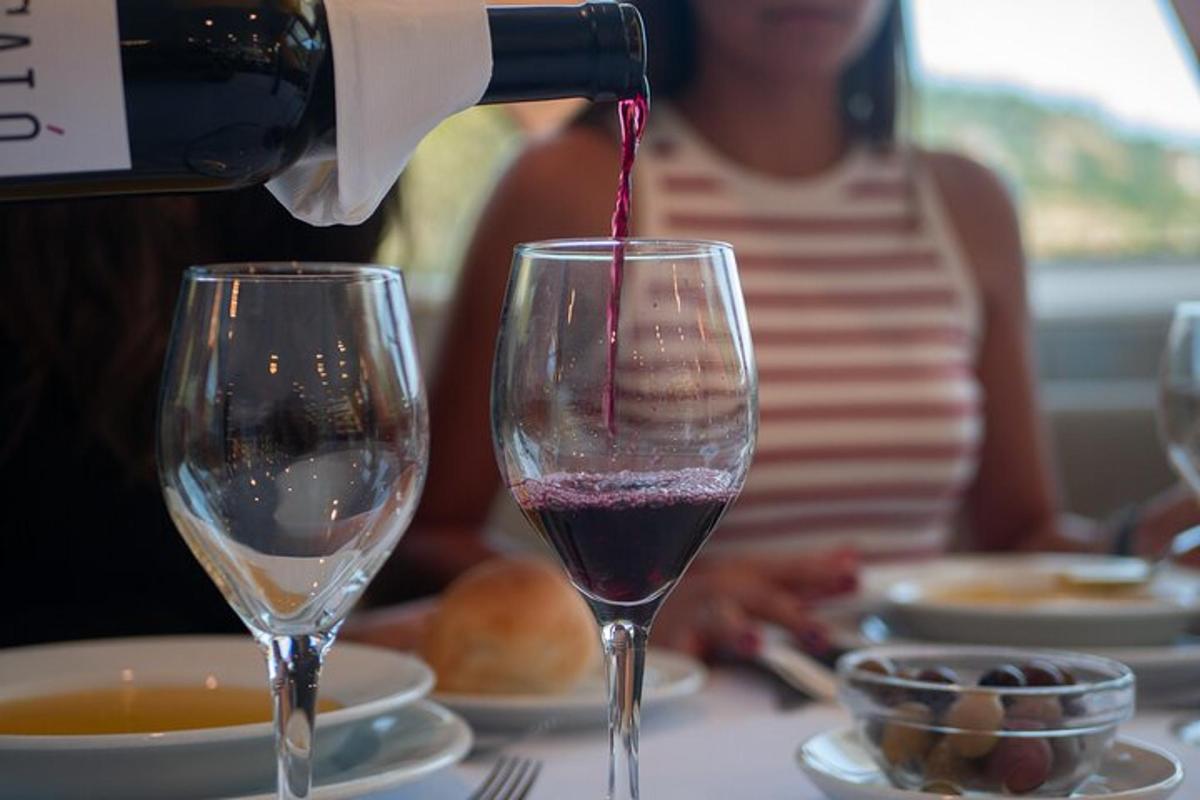 一个人把酒倒进桌上的酒杯里