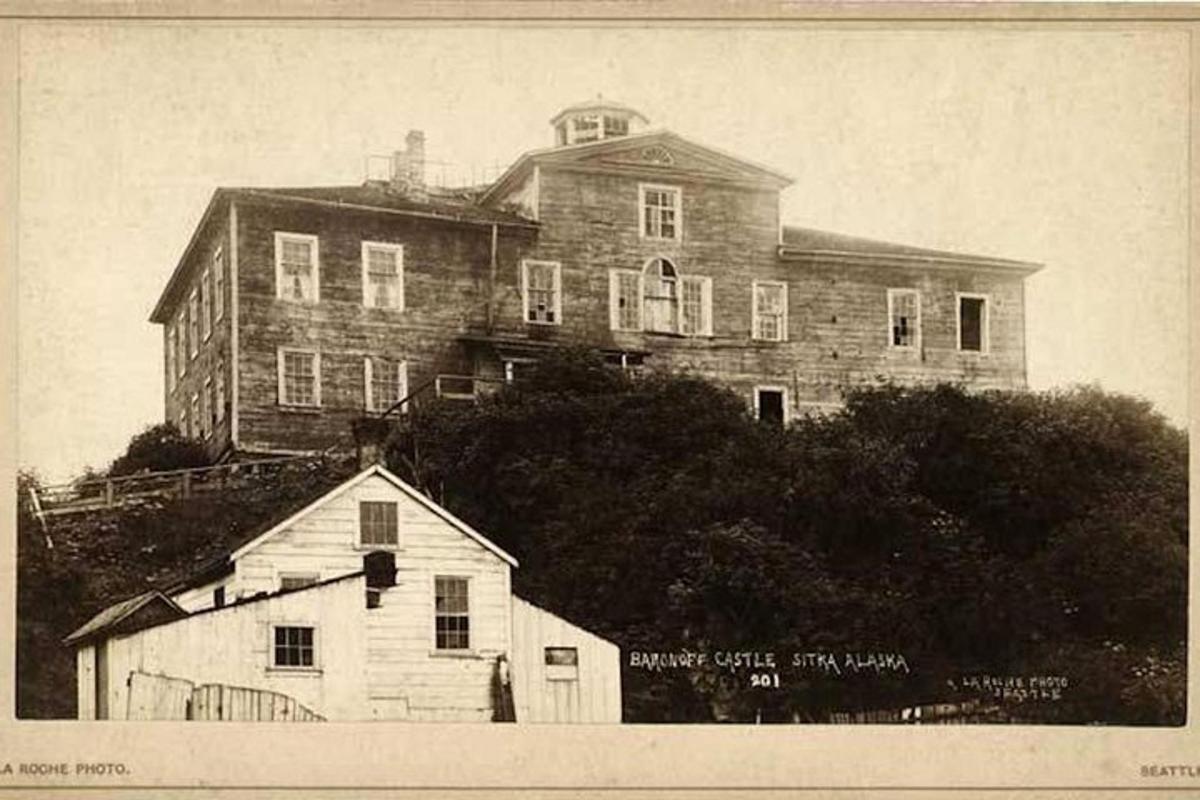 an old photo of a large house on a hill