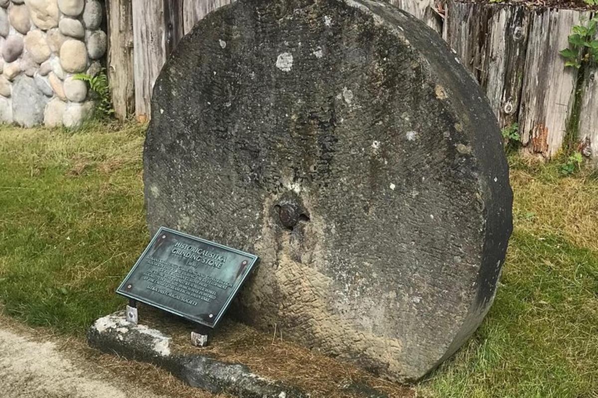a large rock with a sign in the grass