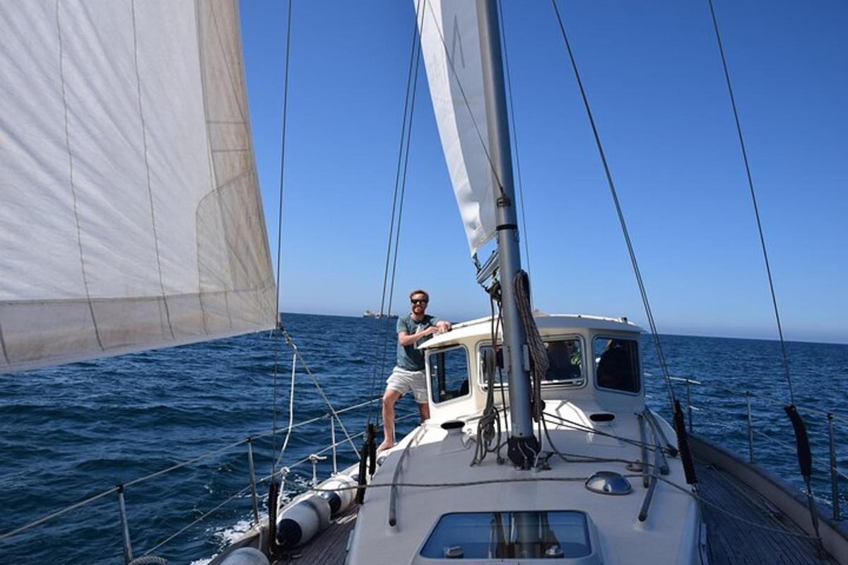 un uomo in piedi sulla cima di una barca a vela