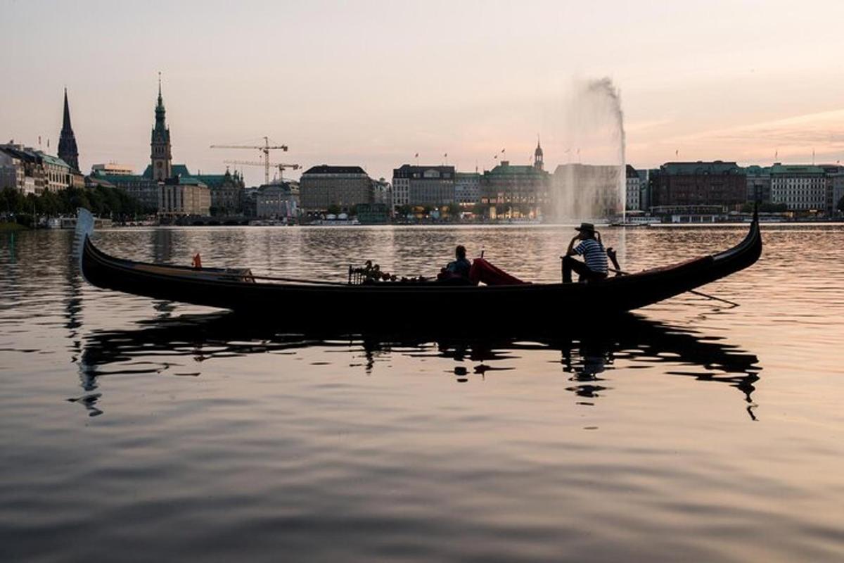 két ember egy gondolában a vízen egy város közelében