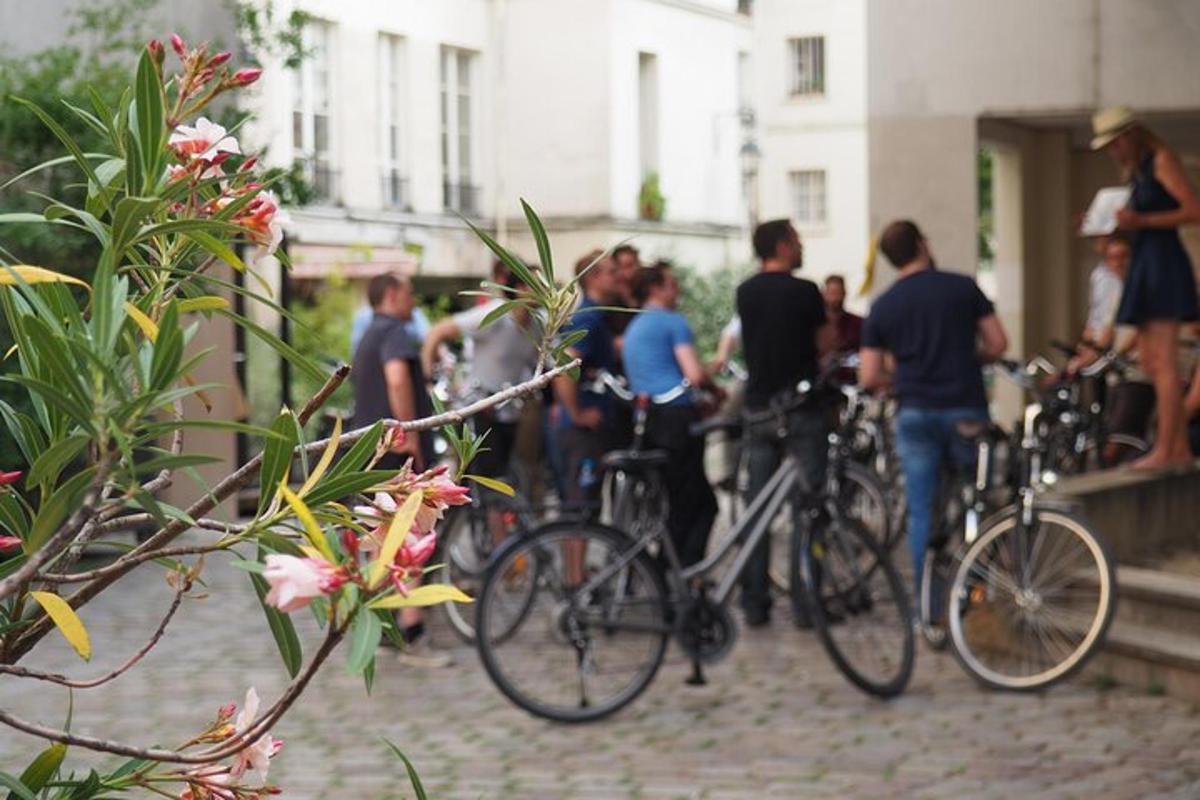 a group of people standing with bikes on a street