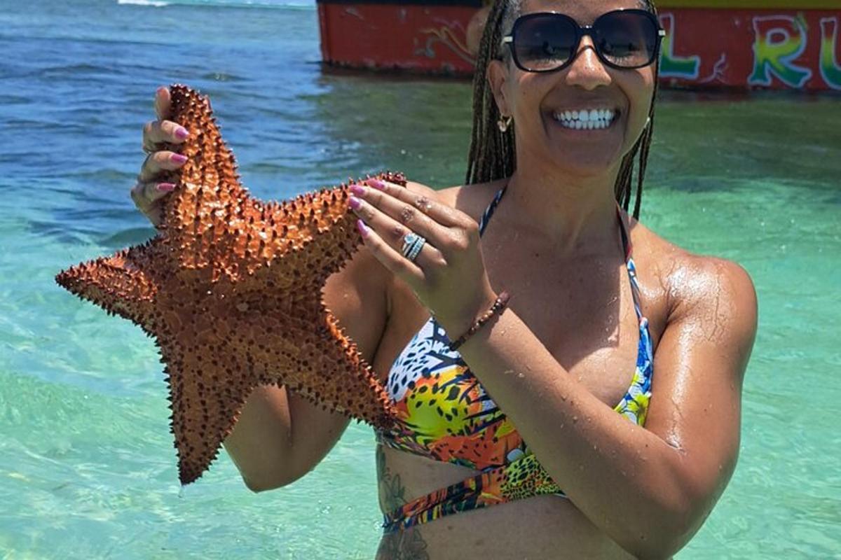 a woman in the water holding a starfish