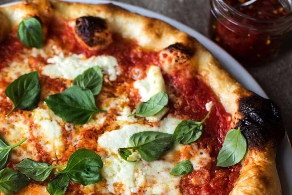 pizza með basilblöðum á diski