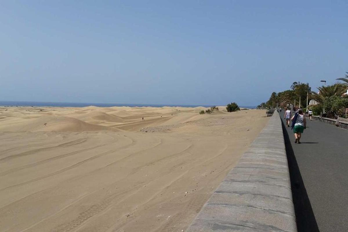 pantai dengan orang berjalan di atas laluan di pasir