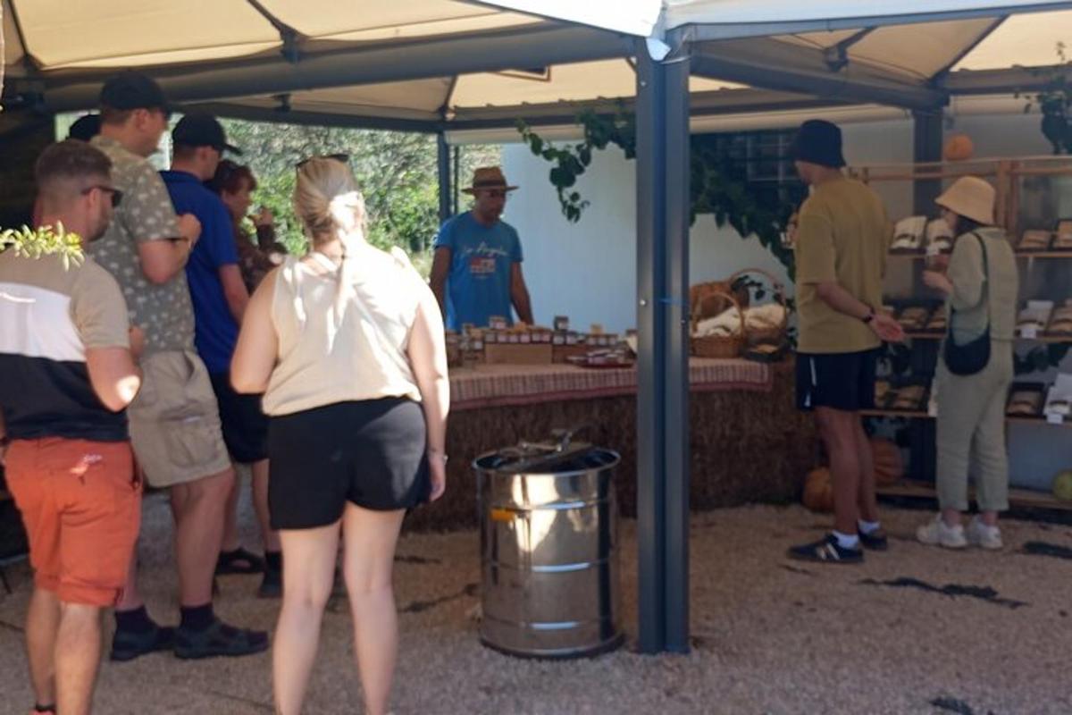μια ομάδα ανθρώπων που στέκονται κάτω από μια σκηνή σε μια αγορά