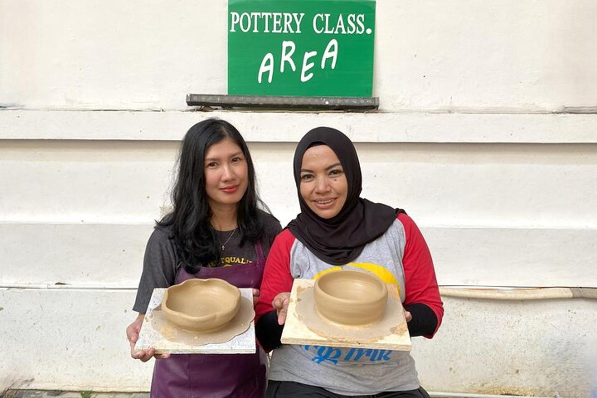 dua wanita mengangkat topi di depan sebuah gedung