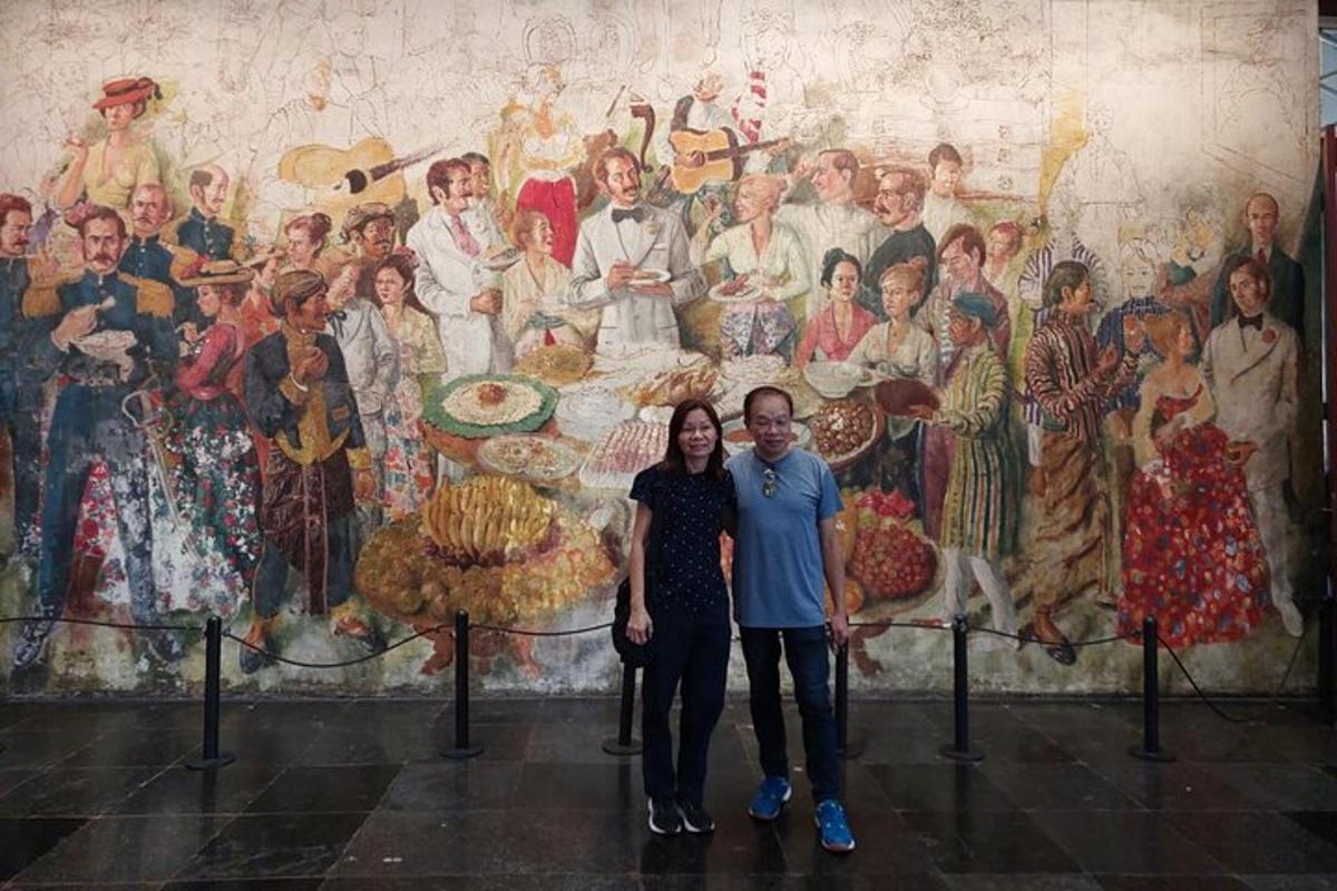 seorang pria dan seorang wanita berdiri di depan mural