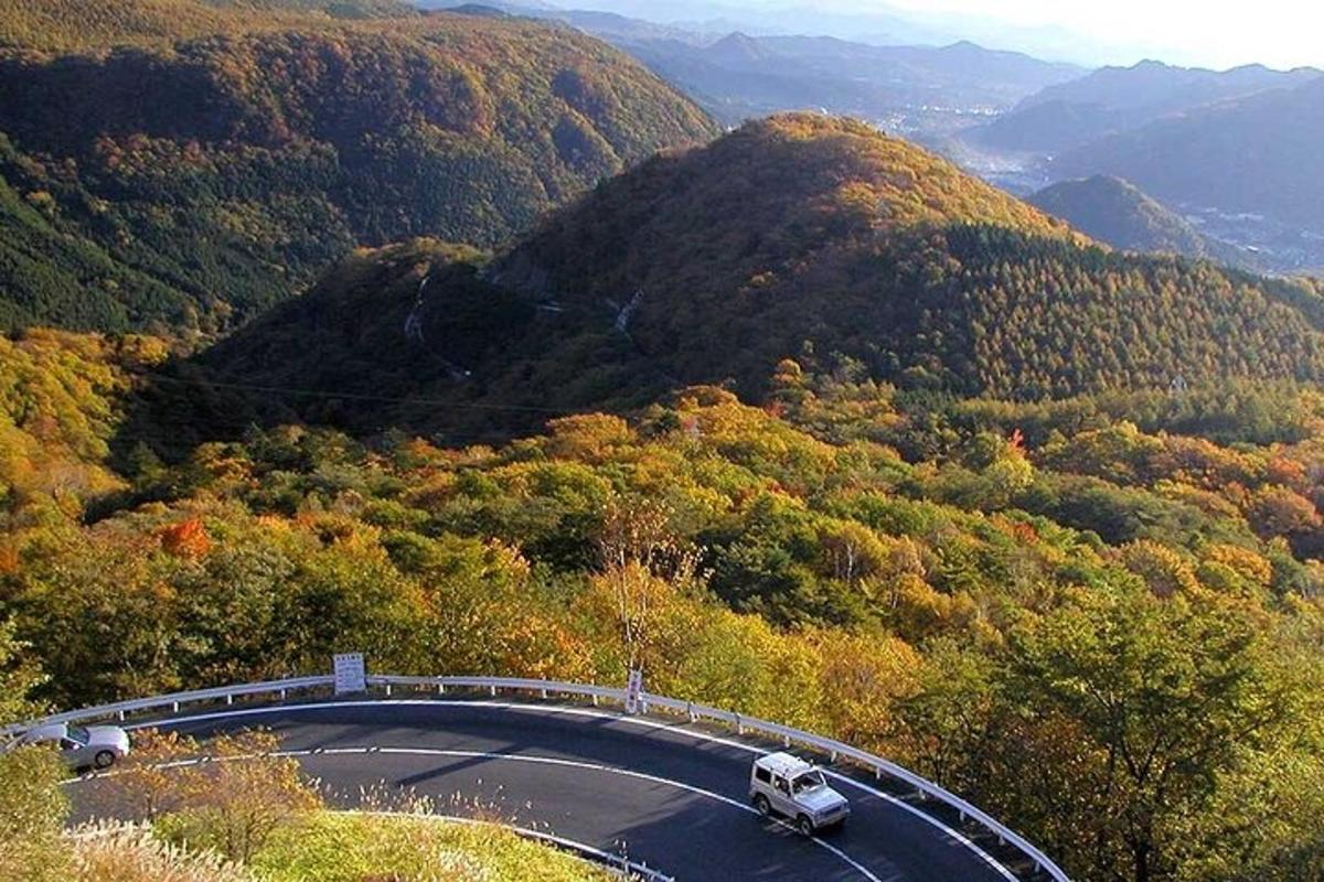 ένα αυτοκίνητο που οδηγεί σε έναν δρόμο στα βουνά