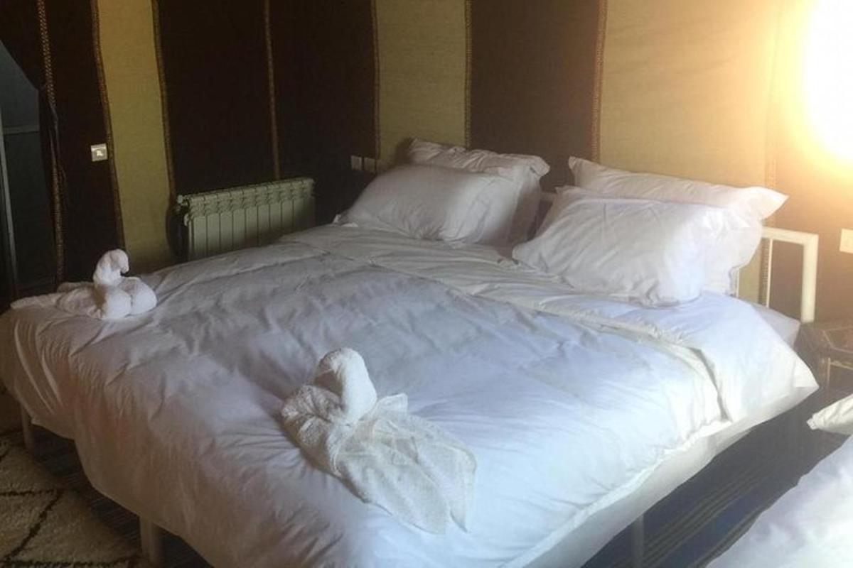 uma grande cama branca com toalhas brancas
