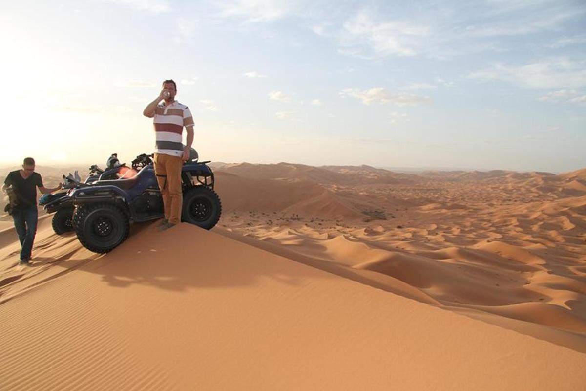 un uomo in piedi in cima a una duna di sabbia nel deserto