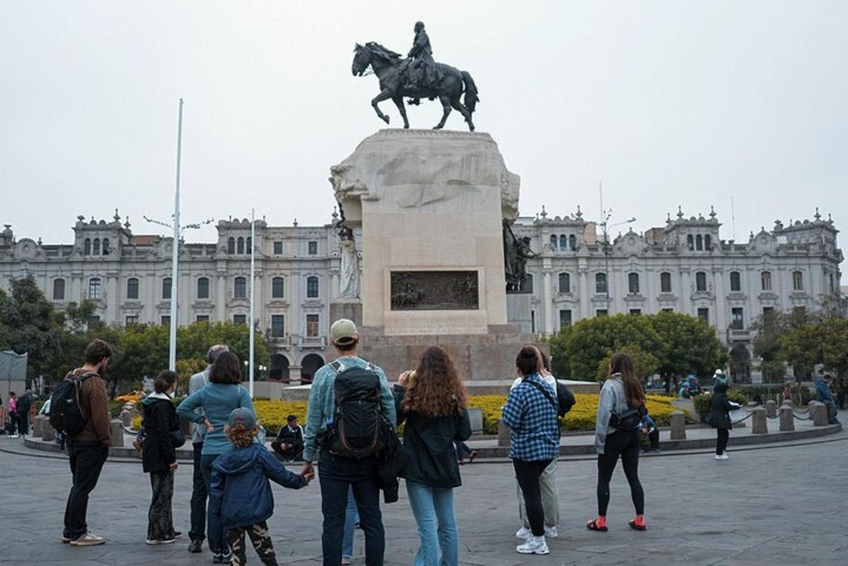 un gruppo di persone in piedi attorno a una statua di fronte a un edificio