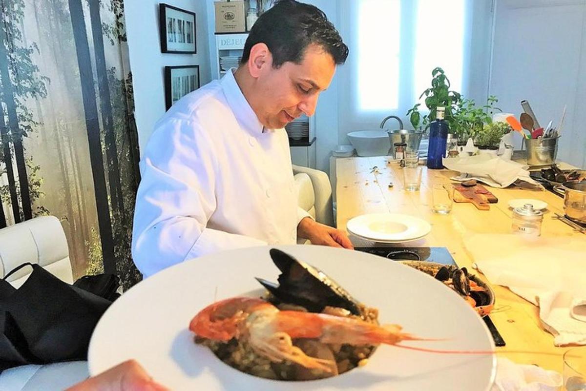 Ένας σεφ στέκεται σε ένα τραπέζι με έναν αστακό σε ένα πιάτο