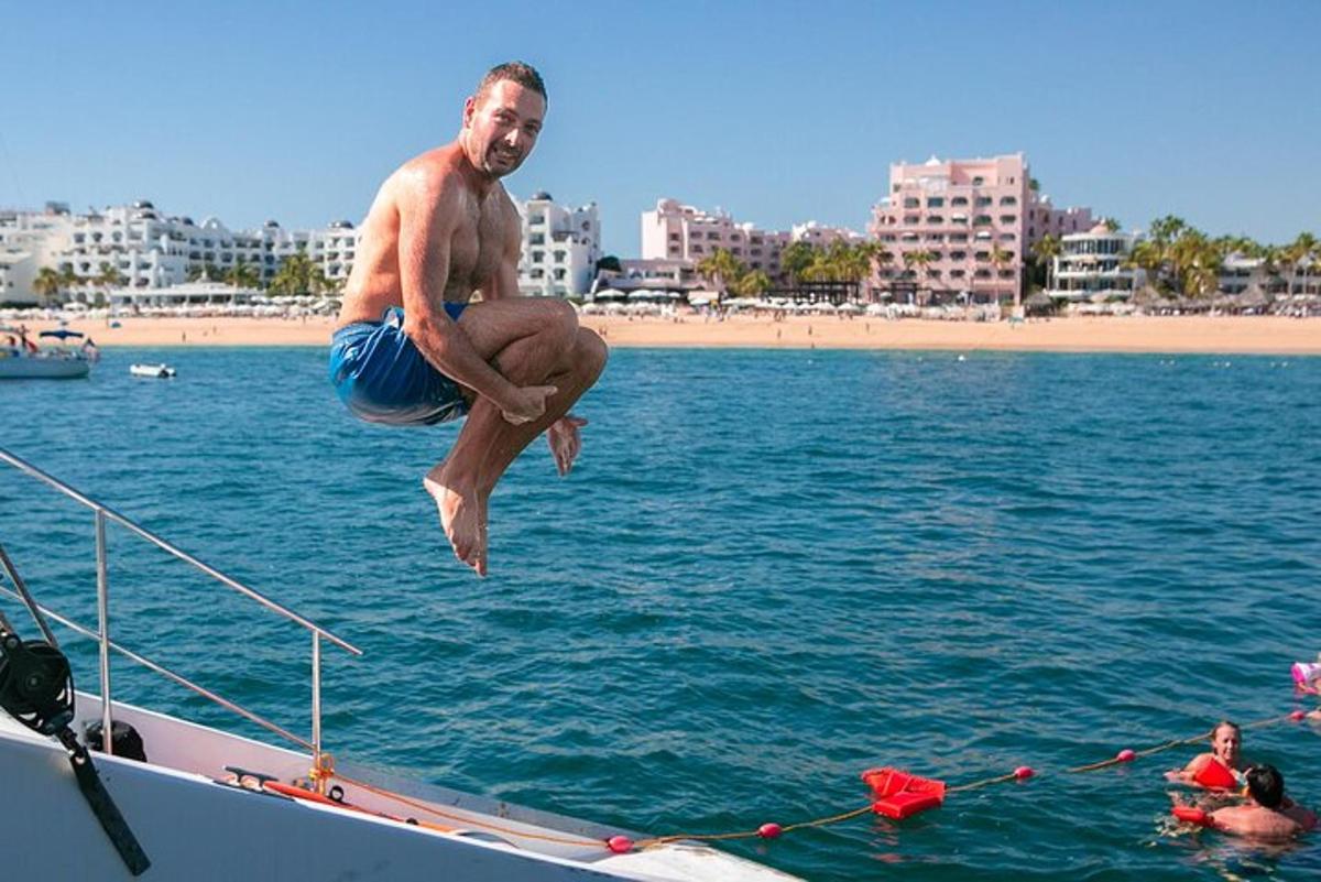 muž skákající z lodi do vody
