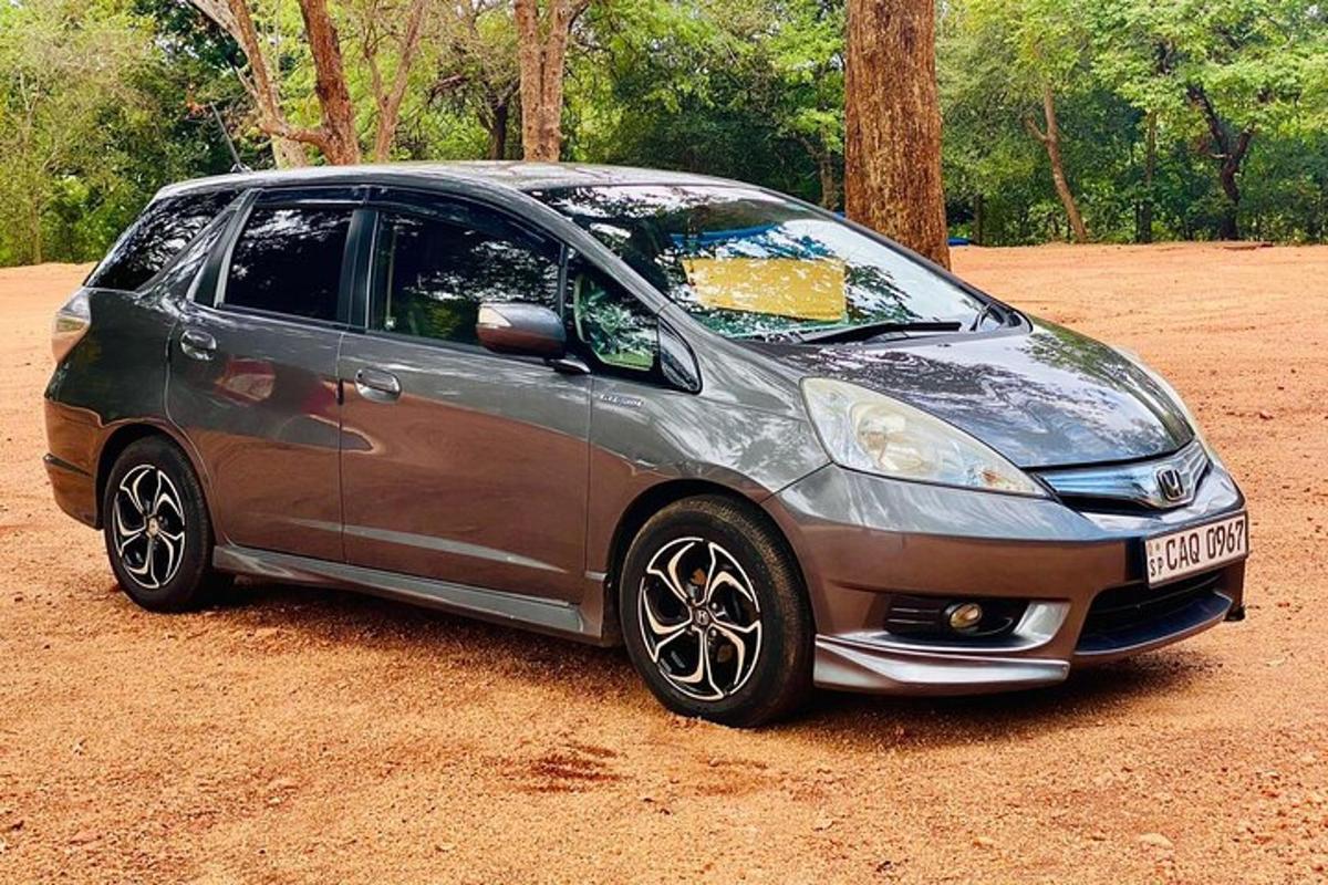 una piccola macchina argentata parcheggiata su un campo sterrato
