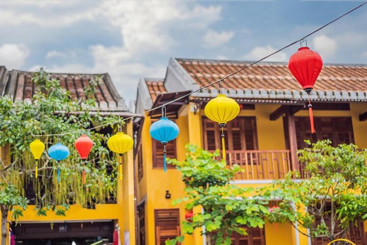 una casa gialla con lanterne colorate davanti