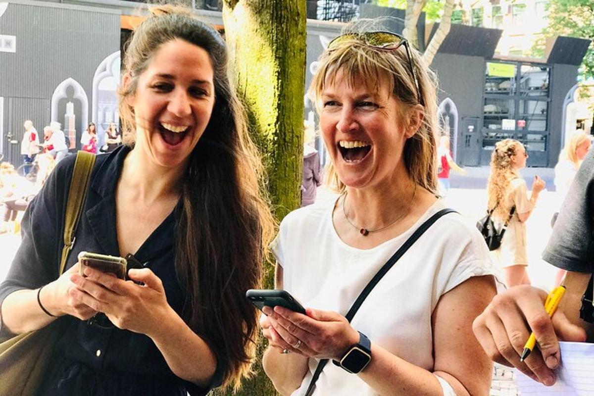 dvě ženy se smějí a dívají se do svých mobilních telefonů