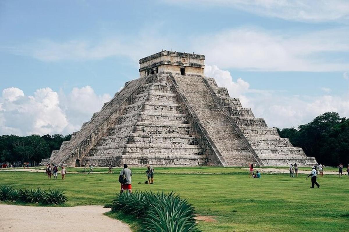 una piramide in un campo con persone in piedi intorno ad essa