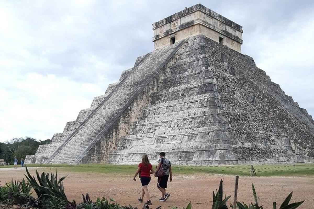un uomo e una donna che camminano davanti a una piramide