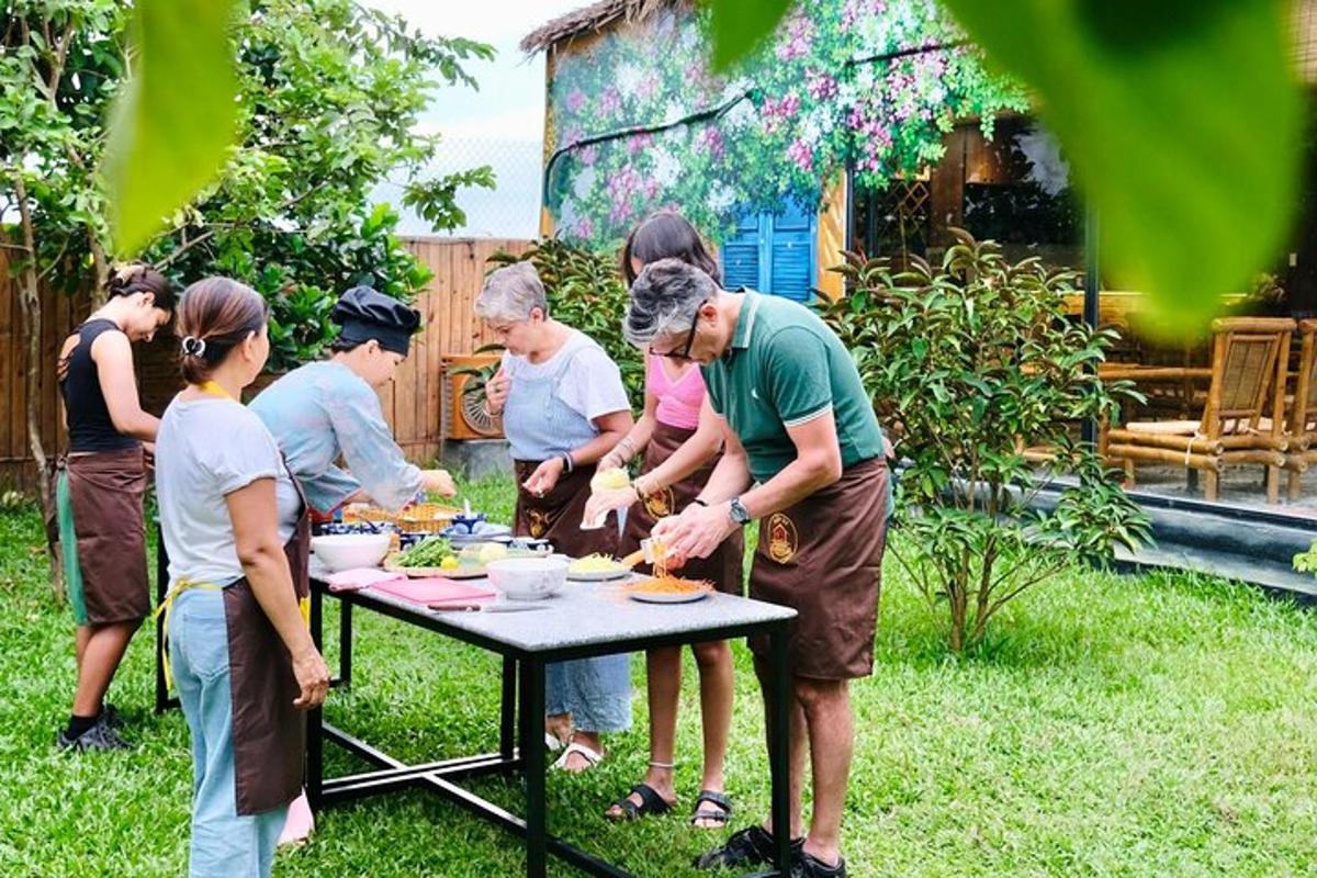 skupina ljudi, ki stojijo okoli mize in pripravljajo hrano