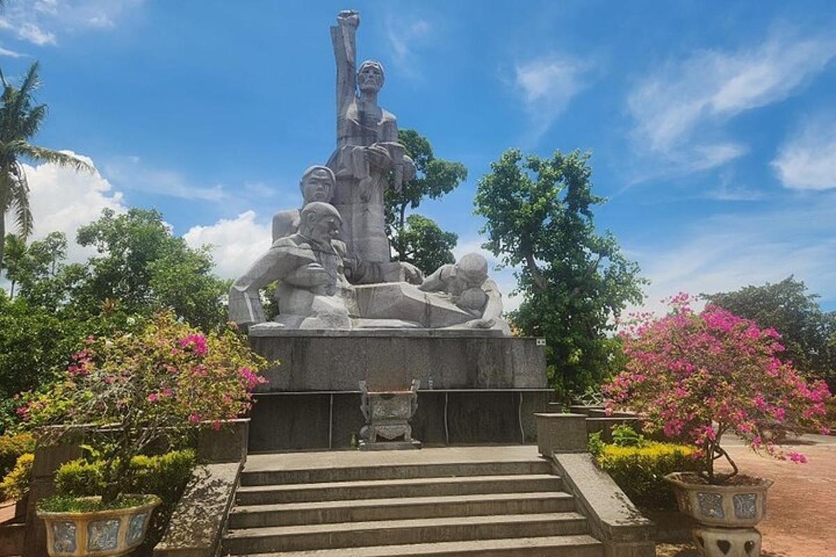 una statua in un parco con scale e fiori