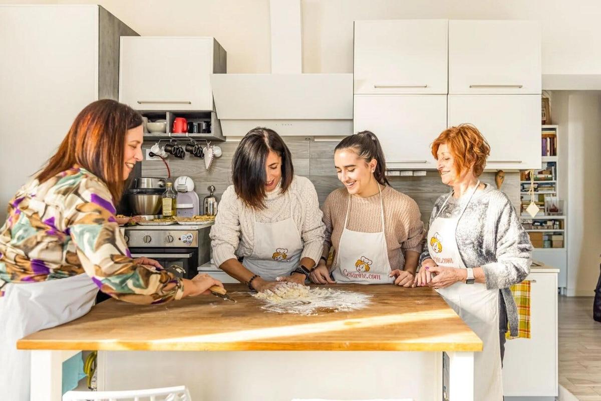 sekumpulan wanita berdiri mengelilingi meja di dapur