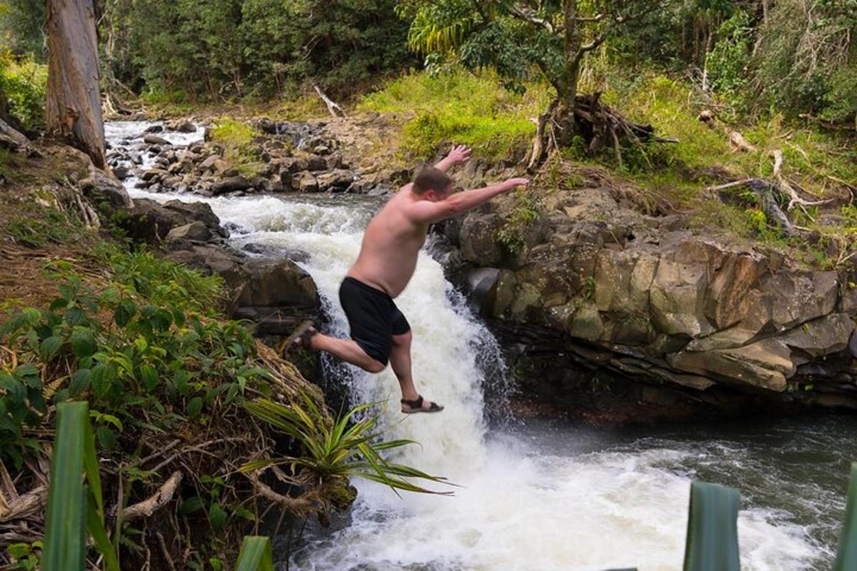 un home saltant d'una cascada a un riu